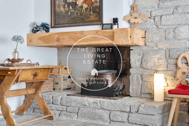 Fireplace with wooden mantle, rustic interior, table, lamp, decorative items, cozy atmosphere.