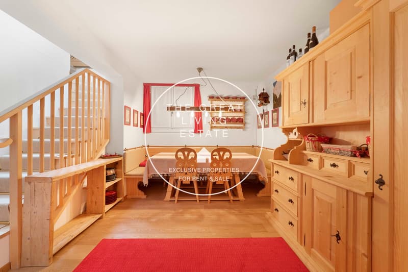 modern kitchen with wooden flooring, kitchen island, wooden cabinet, and red curtains, wooden stairs and wooden floor