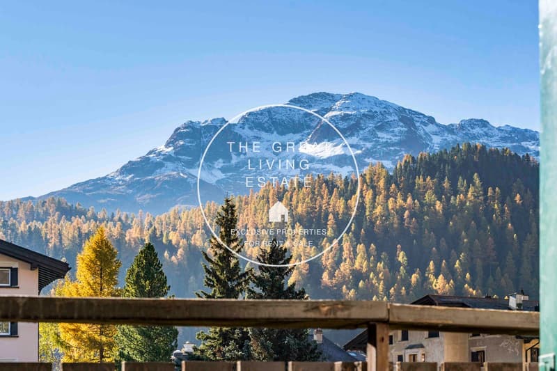 Mountain view, wooden fencing, residential buildings, trees, mountain with snow