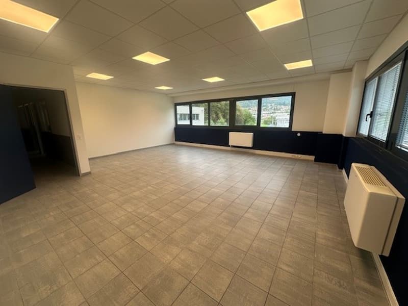 Empty room, tiled floor, white ceiling, blue walls, large windows, window shutters, white wall heater, radiator.