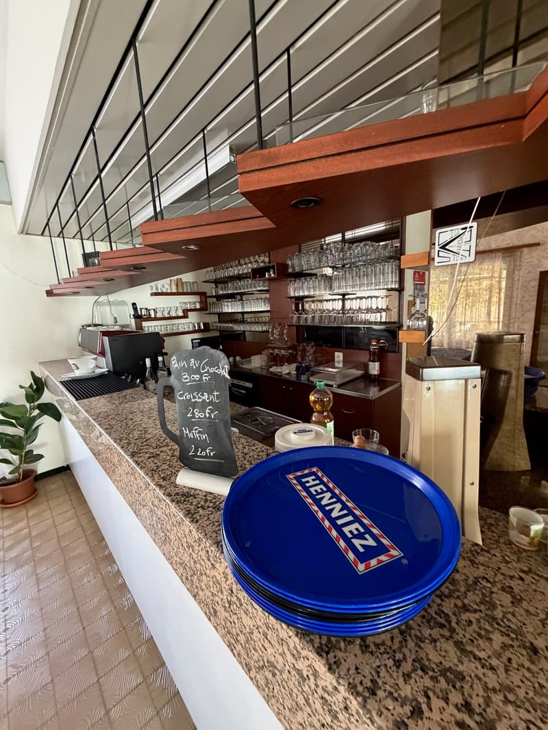 A bar counter in a hotel, with a chalkboard menu board and blue plates.