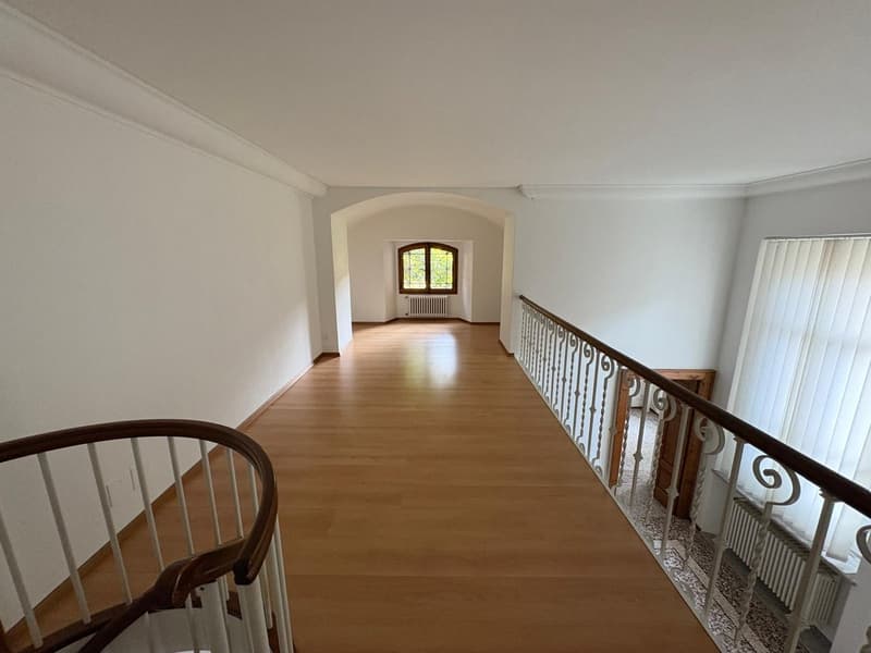 wooden floor, high ceiling, spiral staircase, radiators, white walls