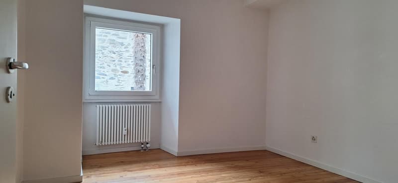empty room, white walls, wooden floor, white radiator, window