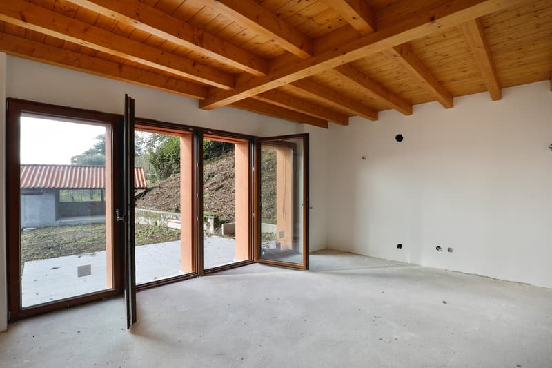 Wooden beams on ceiling, double glass doors, sloped outdoor area