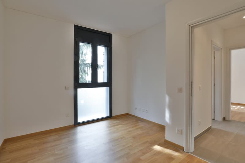 empty room, wooden floor, white walls, large window, power outlets, doors