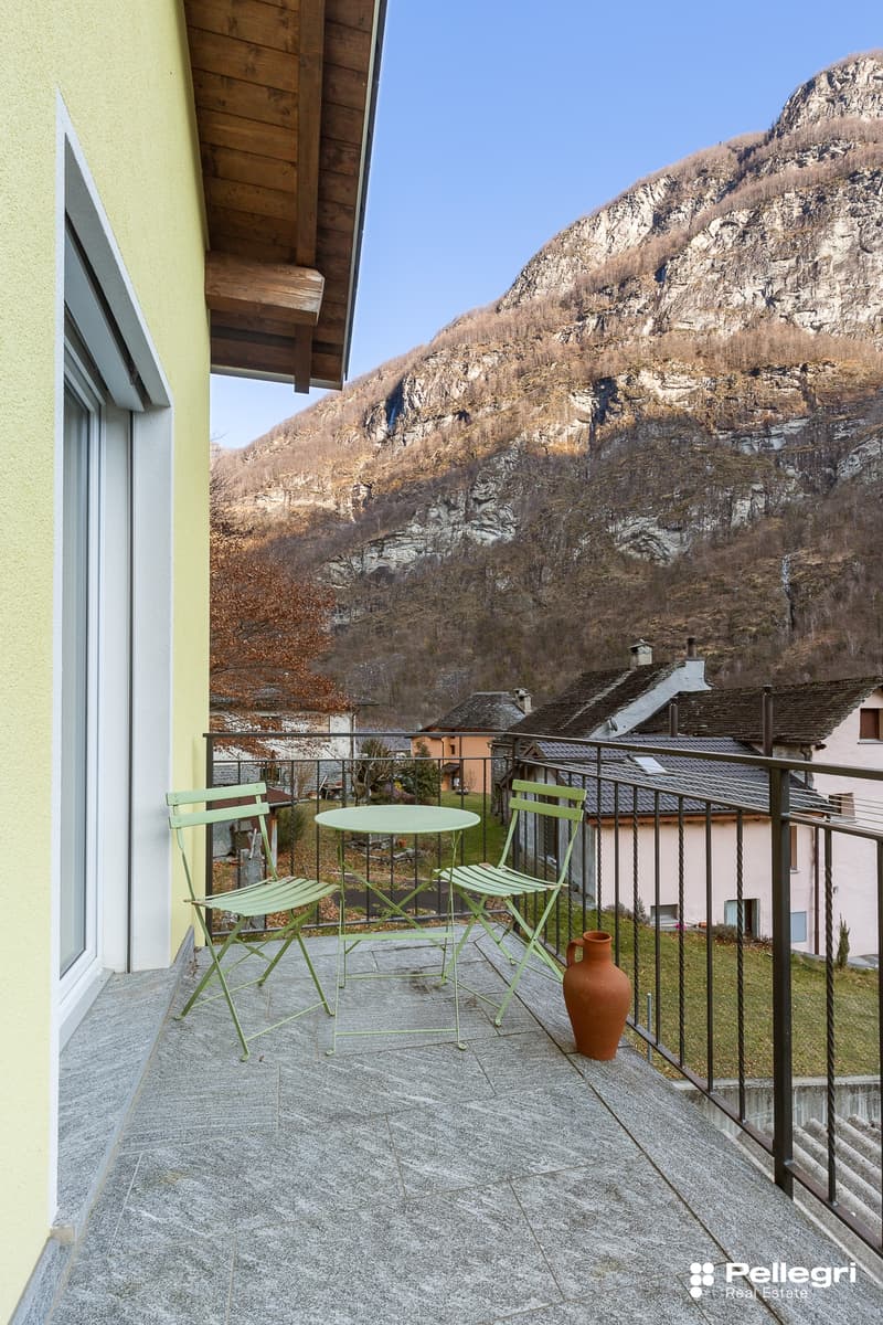 balcony, table, chairs, vase, metal railing, stone floor