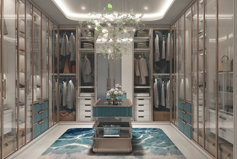 Modern walk-in closet with glass doors, floor-to-ceiling wardrobes, shelves, a central table with a flower vase, decorative rugs, and built-in lighting