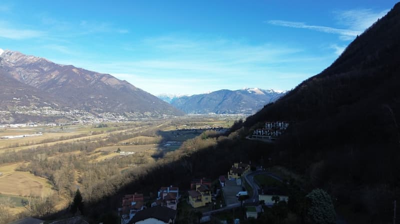 mountain valley, town on hillside, fields, mountains in distance