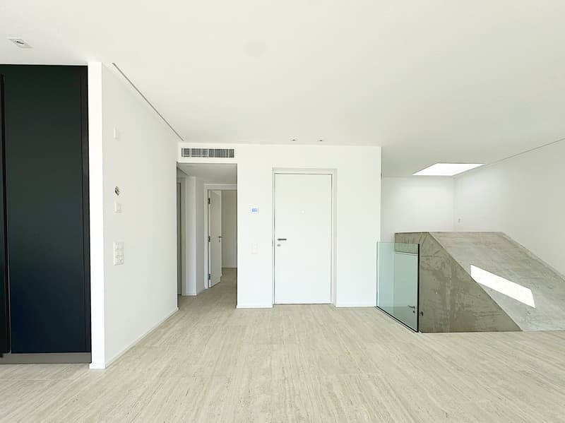 white walls, hardwood floor, a sliding door, a white door, black cabinet