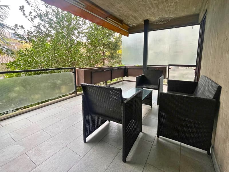 tiled balcony, 3 wicker chairs, glass table, plants