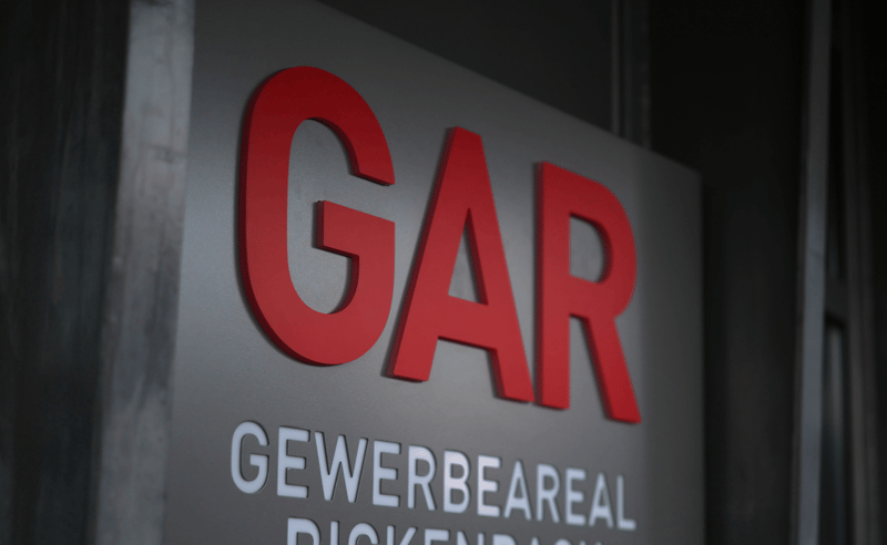 Large red 'GAR' letters on a sign, with 'GEWERBEAREAL DICKENRACH' text below it.