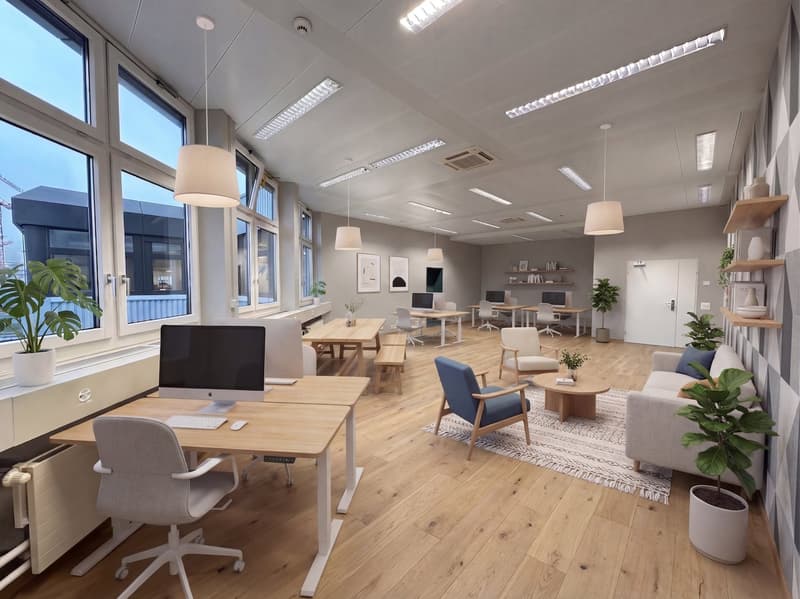 modern office with wooden floors, large windows, desks, chairs, plants, and a couch