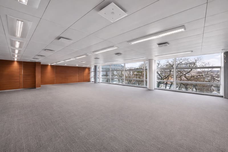 empty room, large windows, gray carpet, suspended ceiling with recessed lighting, exposed wooden pillars, modern design