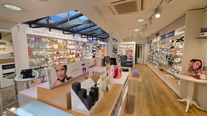 Cosmetics store with wooden floor, glass shelves, and a glass ceiling.