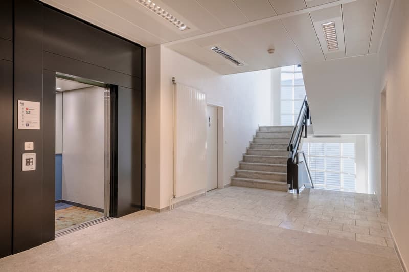 elevator, stairs, tiled floor, white walls, glass window