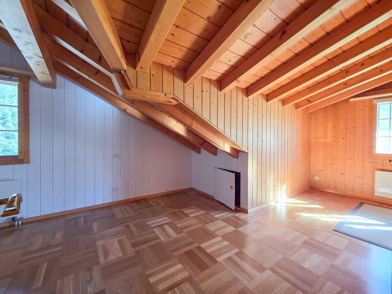 empty attic room, wooden ceiling beams, wooden walls, parquet floor, two windows