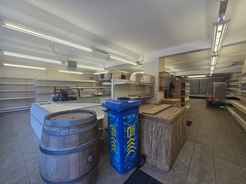 spacious store, shelves, counter, blue recycle bin, wooden barrel, tiled floor, ceiling lights