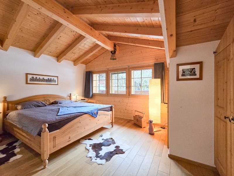 wooden bed, wooden floor, wooden ceiling, two nightstands, two lamps, two picture frames, wooden storage box, cowhide rug, floor lamp