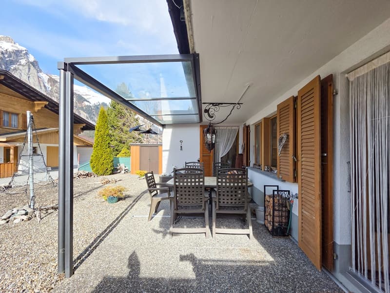 covered patio with table and chairs, metal frame, glass roof, wooden shutters, mountain view