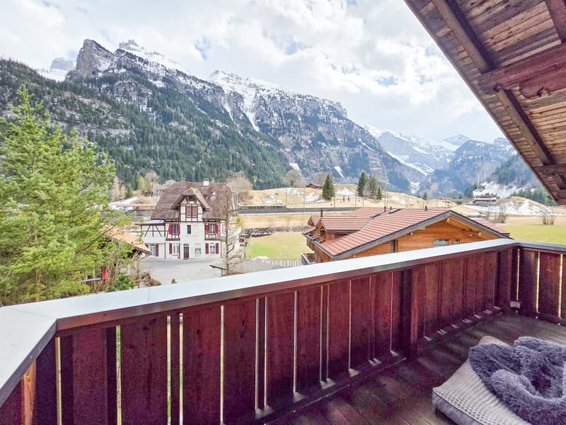 wooden railing, wooden floor, view of mountains, trees, houses, and fields