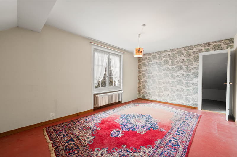 empty room, carpet, window with white curtains, light fixture, radiator, door leading to another room