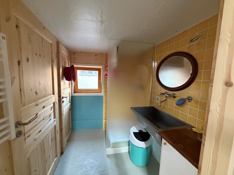 small bathroom with washing machine, sink and mirror