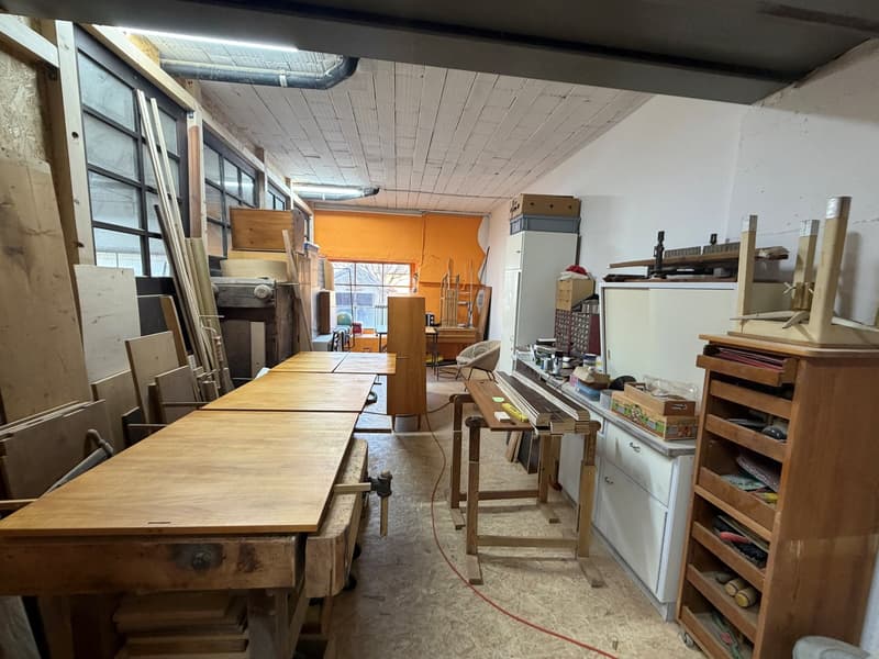 workshop with wooden tables, cabinets, shelves, and various tools and materials