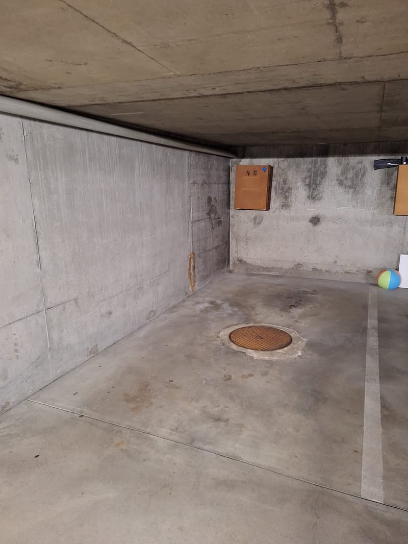 Empty parking space with a manhole cover in the middle