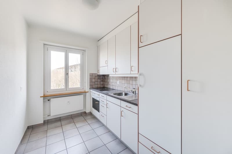 modern kitchen with white cabinets, tiled floor, window, sink, stove, refrigerator
