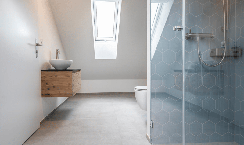 modern bathroom with white sink, wooden cabinet, white toilet, glass shower, hexagonal tiles