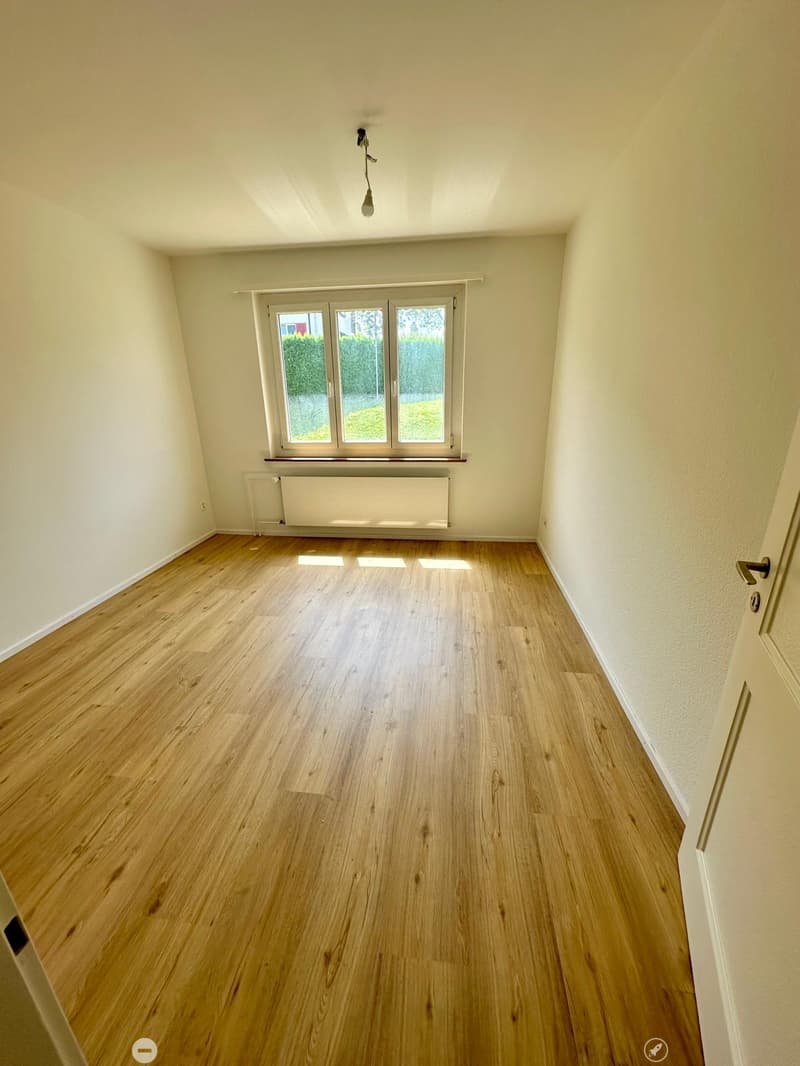 empty room, wooden floor, white walls, large window, radiator
