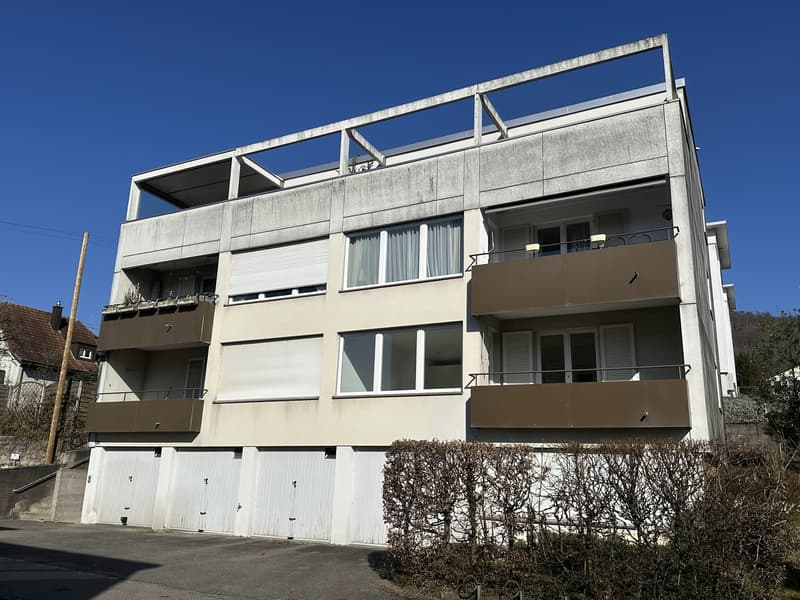 4 story building, white exterior, multiple balconies, 4 garages