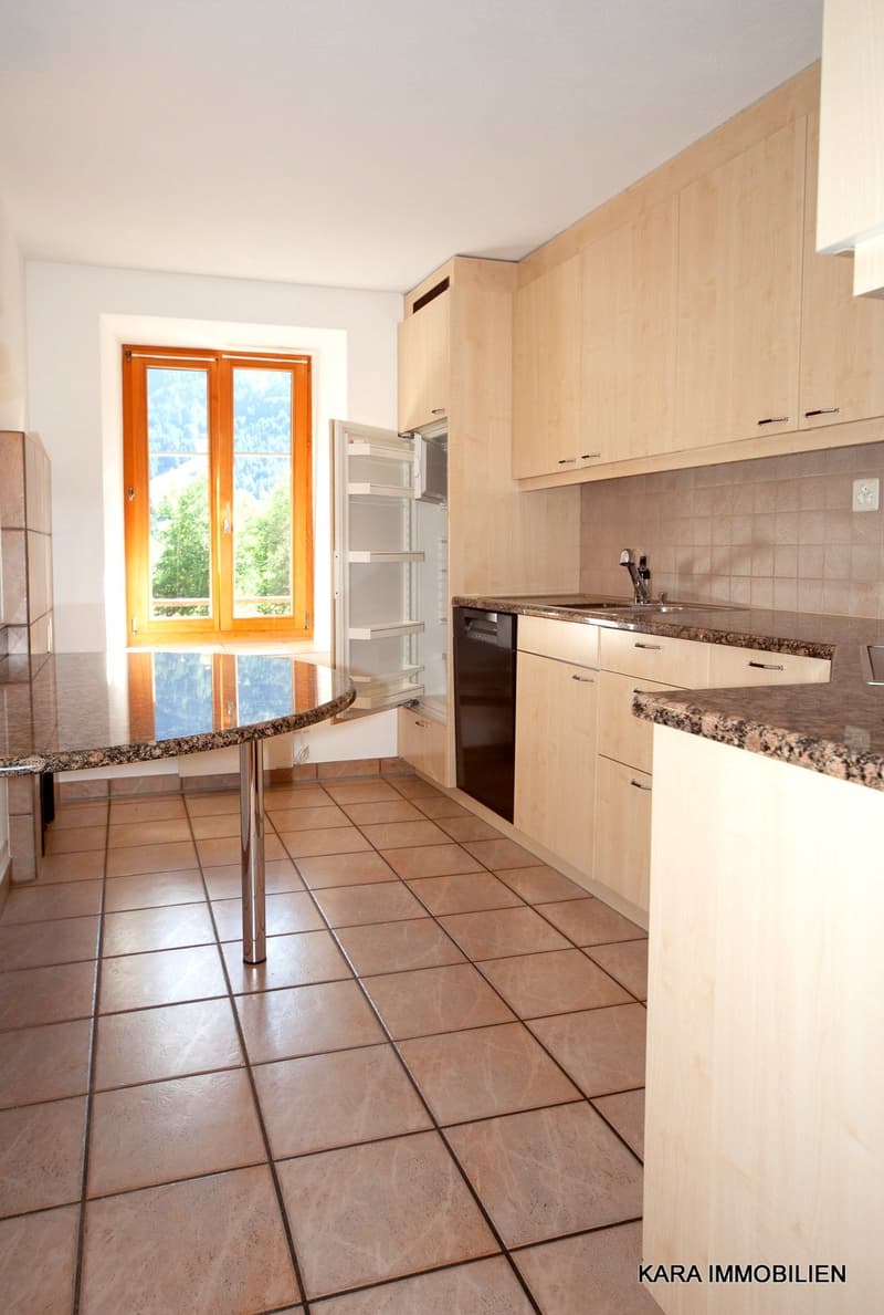 modern kitchen with large window, granite countertops, stainless steel appliances, and tiled flooring