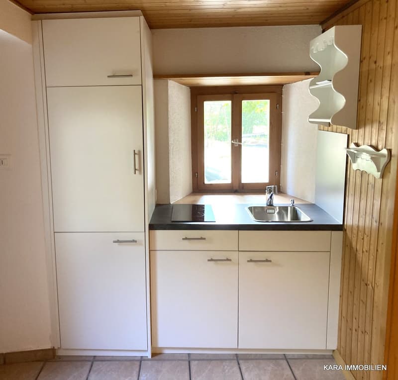 White kitchen, wooden wall, sink, stove, window, wooden floor, cabinets