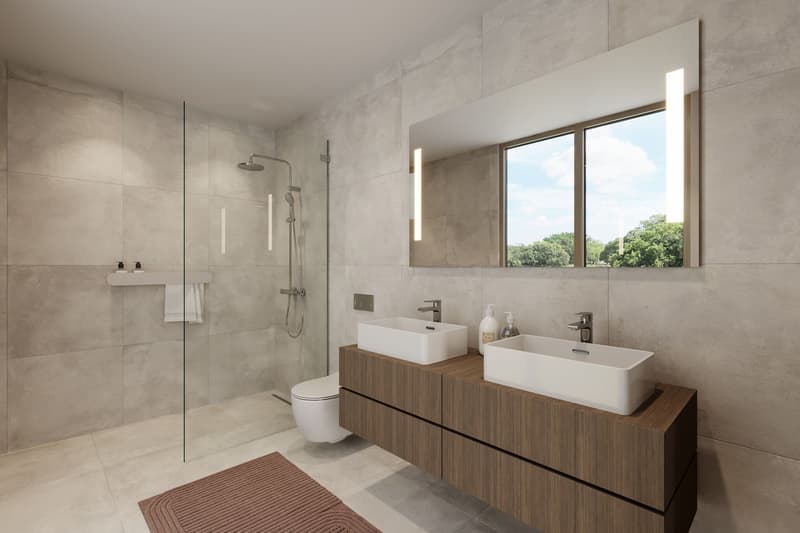 modern and spacious bathroom, with two sinks, a shower stall, and a toilet, all with white ceramic, and modern fixtures