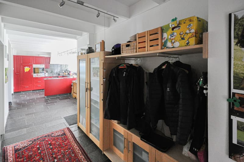 corridor with shelves, closet, rack, kitchen with red cupboards and kitchen island
