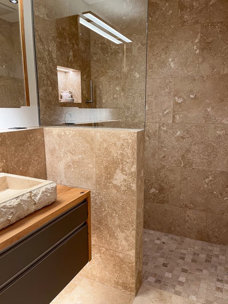 modern bathroom, walk-in shower, wooden counter, large mirror, beige tiles