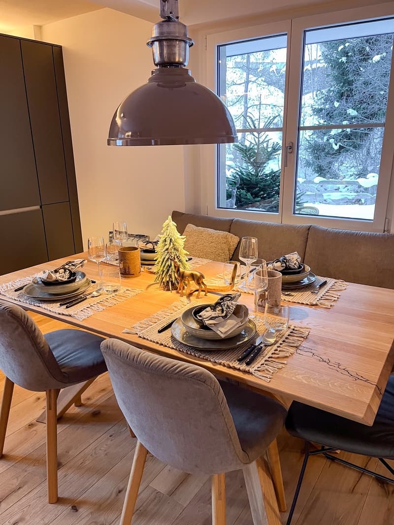 Dining room, wooden table, grey chairs, lamp, winter decoration, sofa, couch, windows