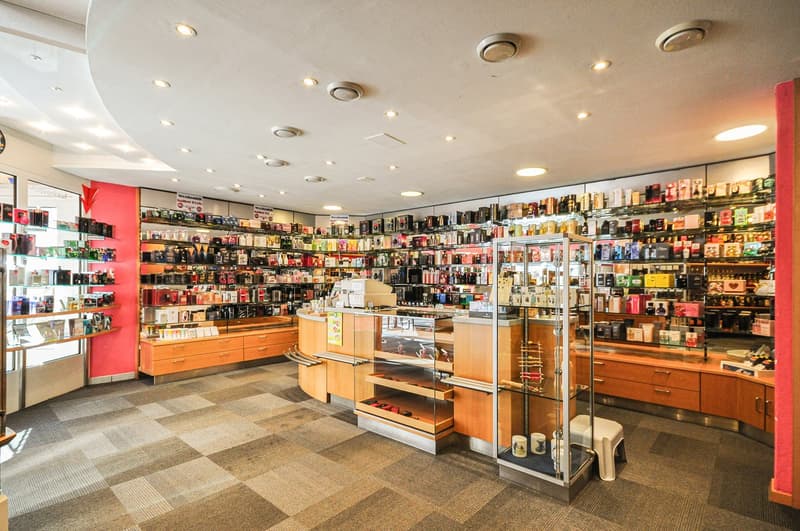 interior of a shop with checkered floor, round open shelves with a variety of products and a wooden counter