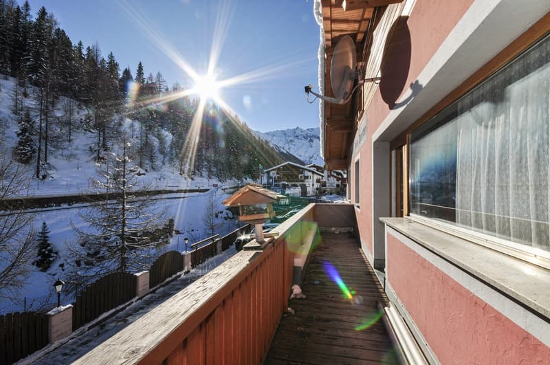 balcony with wooden railing, mountain views, snow