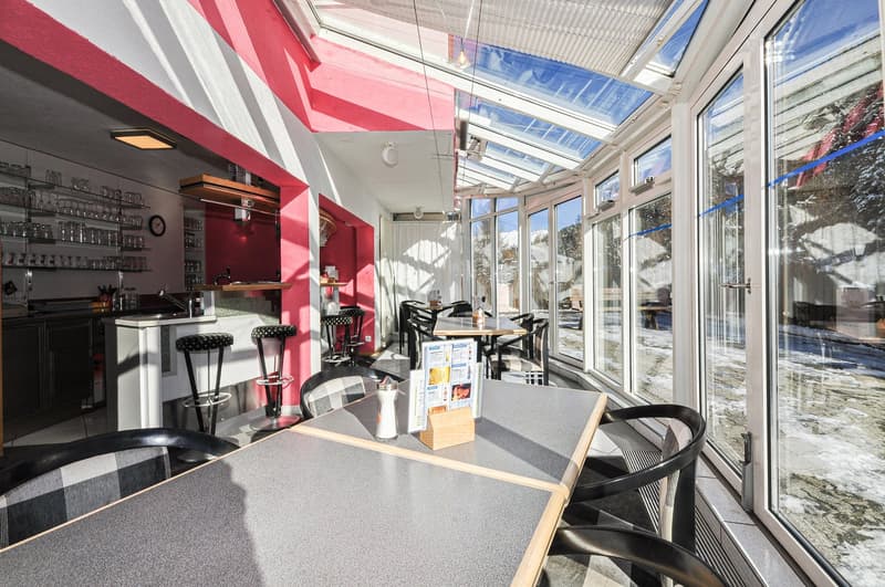 Dining room with large windows, modern furniture, tiled flooring, tables, and chairs, glass partition, glass roof, kitchen counter