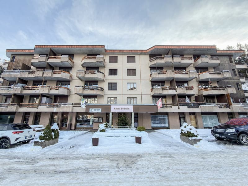 Chasa Belmunt building with multiple balconies, entrance, multiple floors, winter surroundings