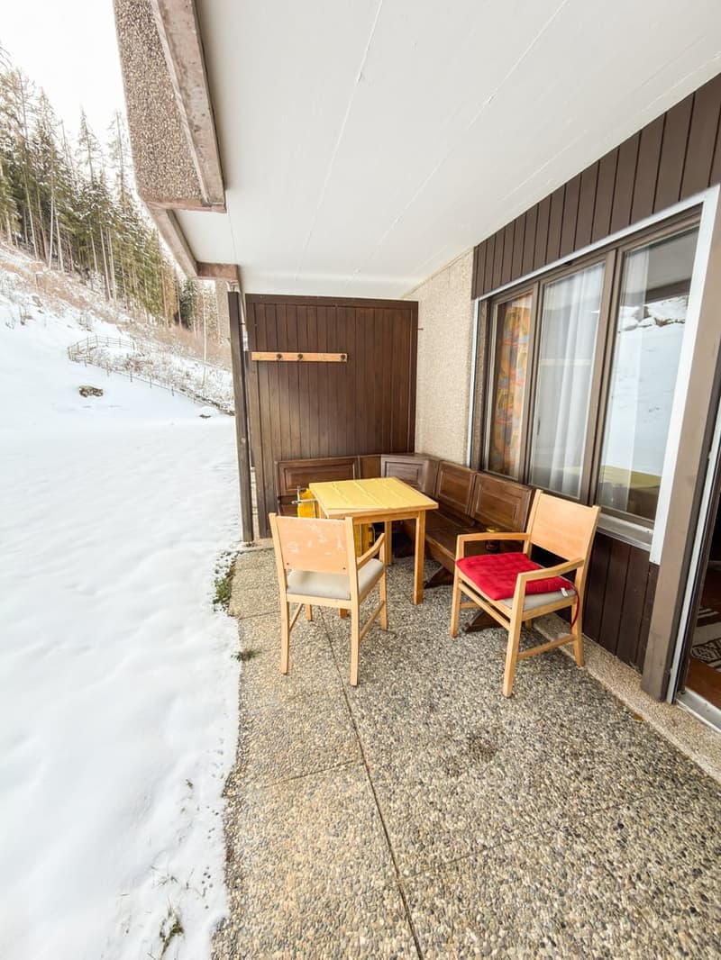 yellow table, bench, chairs, winter snow on ground, brown paneling, clear skies