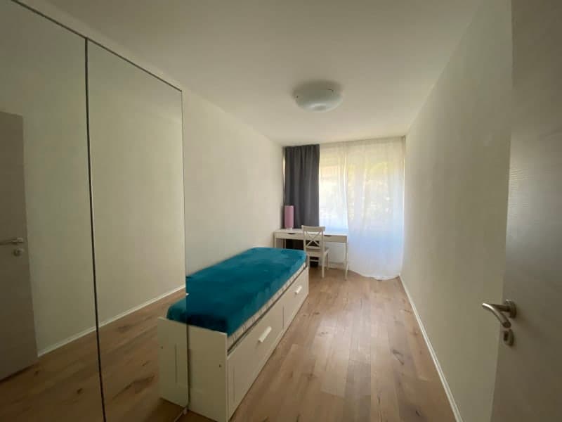 small room with bed, study table, and drawers