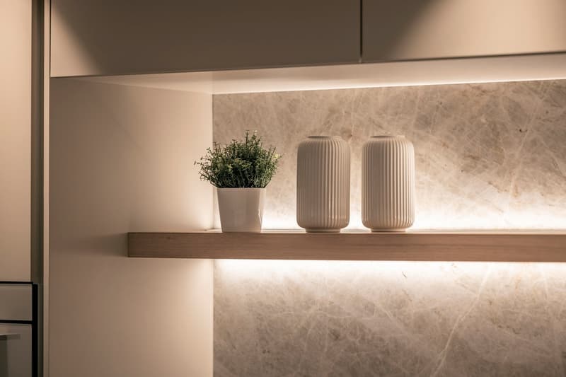 Marble countertop, wooden shelf, white ceramic vases, potted plant