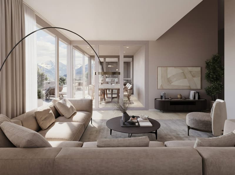 A modern living room with a beige color palette. Features a couch, an ottoman, a wooden coffee table, and a curved floor lamp. It has glass doors that lead to a terrace overlooking mountains and another room. There's also a table with chairs in another ro