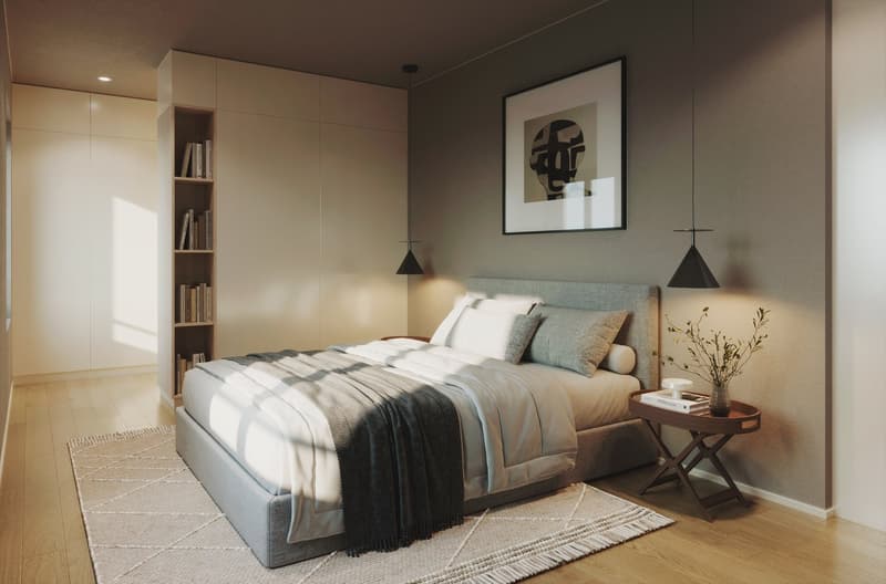 A bedroom with a bed, nightstand, rug, and a bookshelf with books. The wall is painted in a light gray color, and there is a picture frame hanging on the wall. The bed has a gray headboard and is covered with a white blanket and a black blanket. The night