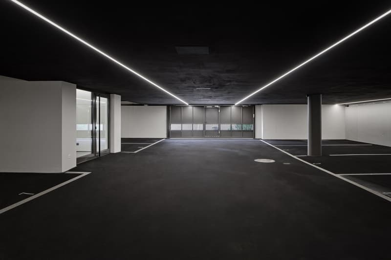 Empty car parking area with dark walls and ground, and LED lighting on the ceiling