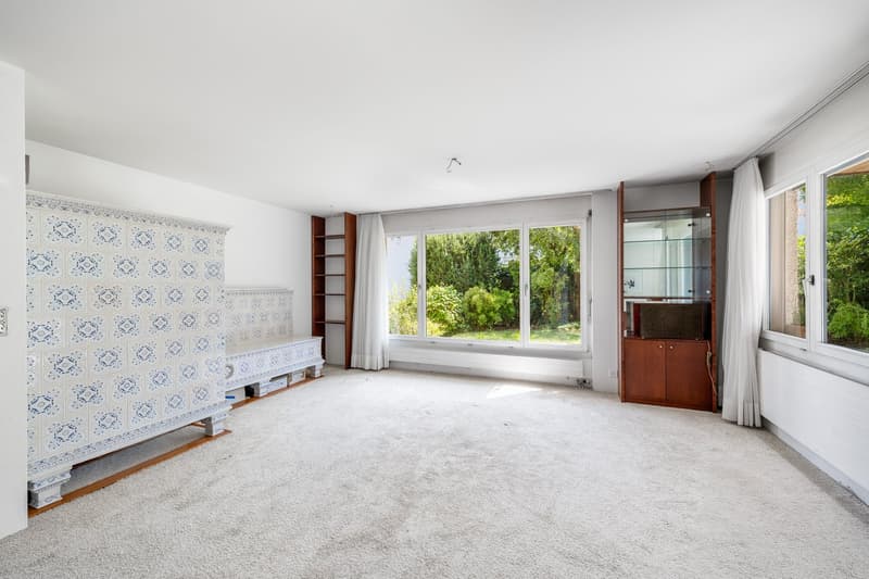Empty room with white walls, white tile, large window with view, wooden shelves