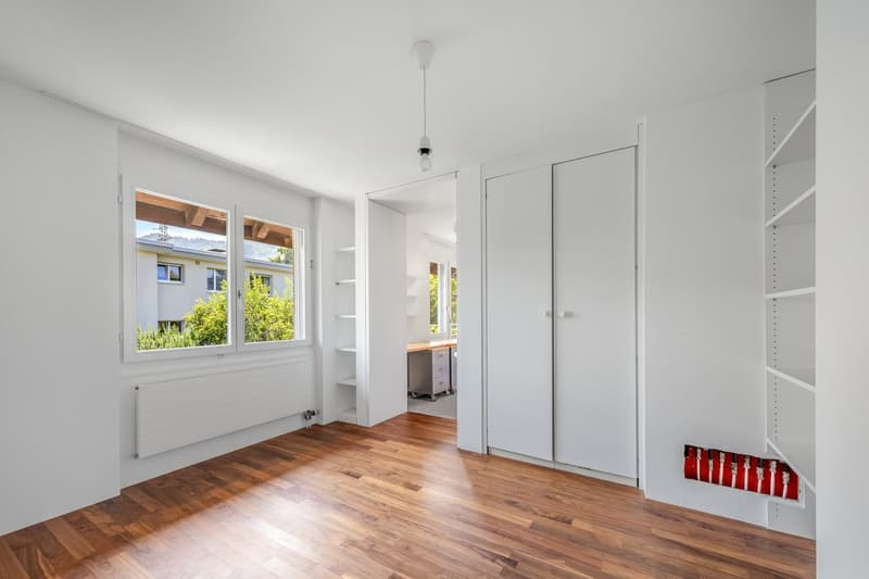 empty room, white walls, wooden floor, large windows, double doors leading to hallway, small radiator under window